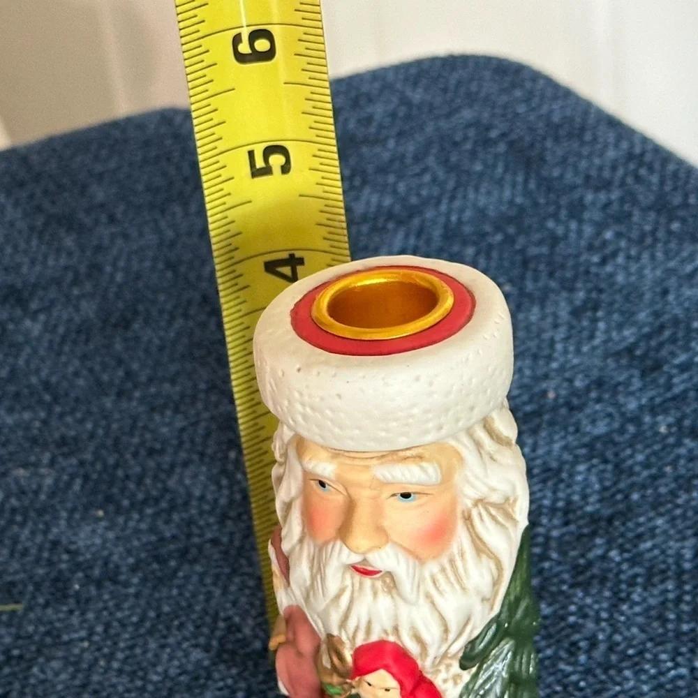 Cute Santa ceramic candleholder. Multiple smaller Santas surrounding the holder.